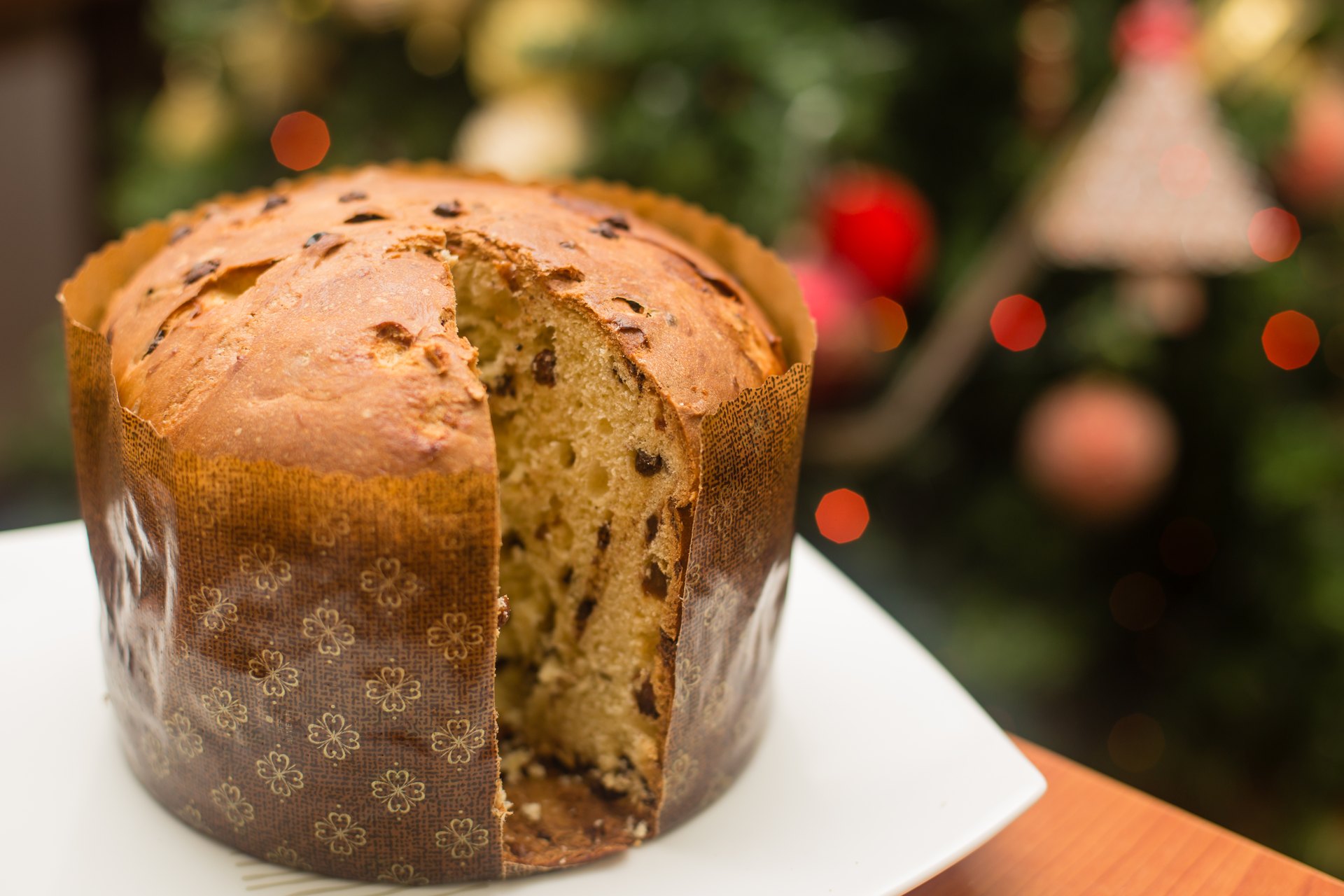 Cut panettone with raisins and candied fruit visible in the crumb