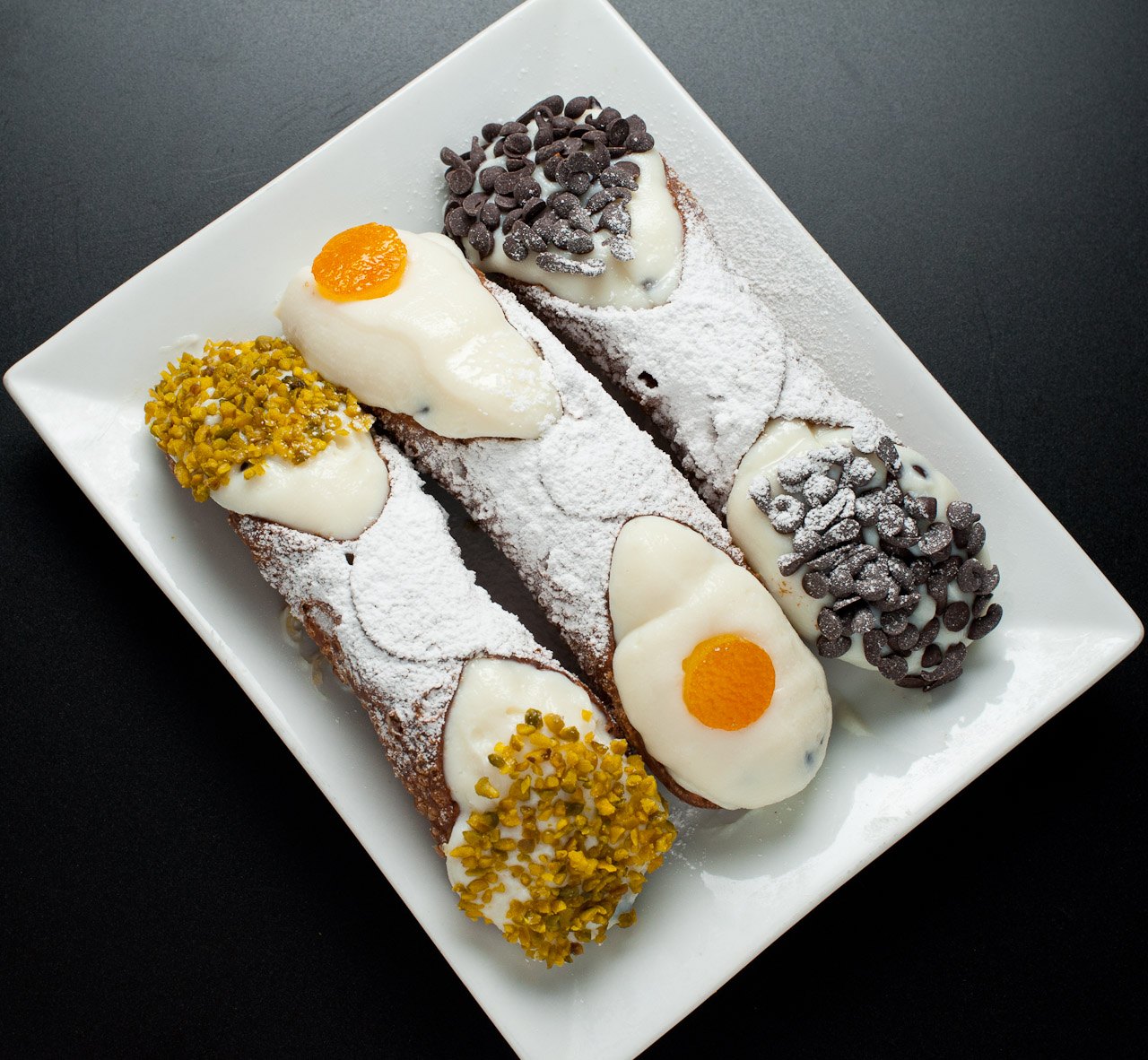 Sicilian cannoli filled with ricotta and finished with pistachios and chocolate